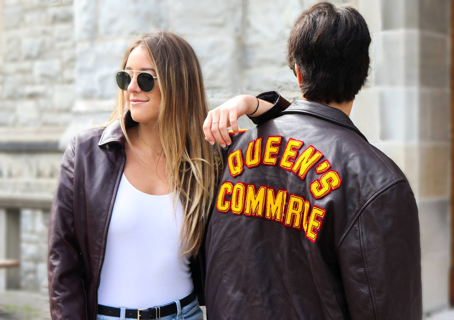 Two Queens students posing in Commerce leather jackets
